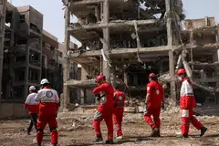 A Red Crescent rescue team works next to a building that was damaged by a strike, amid the U.S.-Israeli conflict with Iran, in Teheran, Iran, March 17, 2026. 