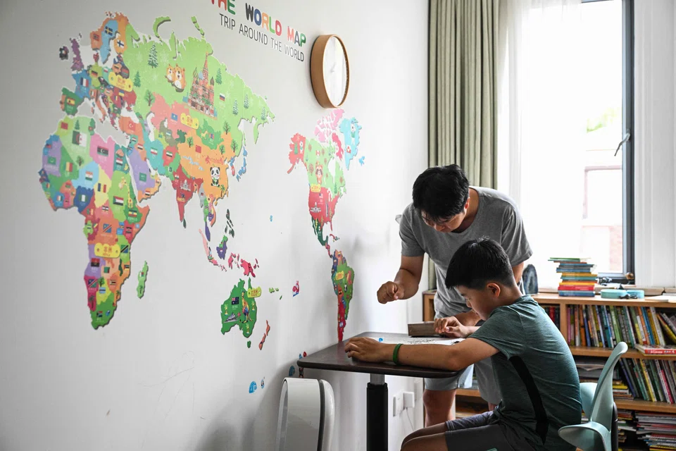 Stay-at-home dad Chen Hualiang interacts with his son Elvin at their home in Shanghai, China, Aug 9, 2024.