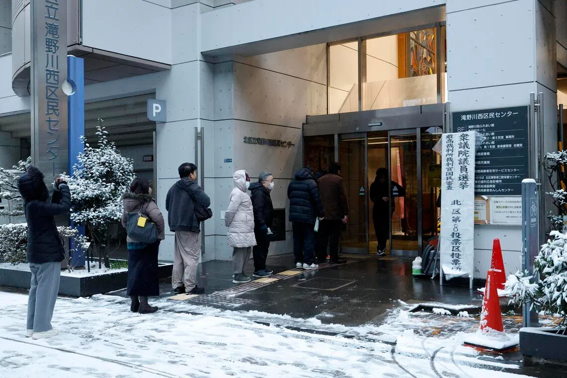 Voters line up at a polling station to vote for the Lower House election in Tokyo, Japan on Feb 8.