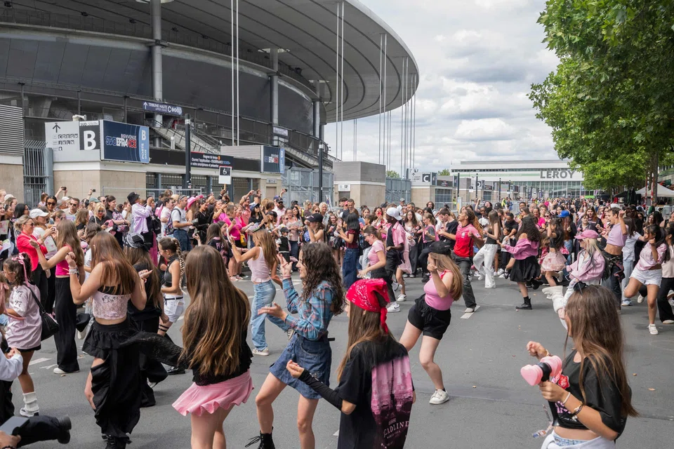 Fans dancing outside a stadium in France prior to a concert by South Korean group Blackpink. Audience data shows that there are now far more K-pop fans outside South Korea than at home.