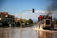 People are evacuated by an excavator from a flooded area in Larissa, central Greece. Climate change can disrupt business operations, evaporate demand, impose obsolescence and shrink market share.