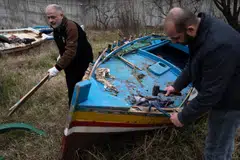 Inmates collect wood from a migrant boat to make music instruments as part of the "violins of the sea" project at the Opera near the Italian city of Milan.