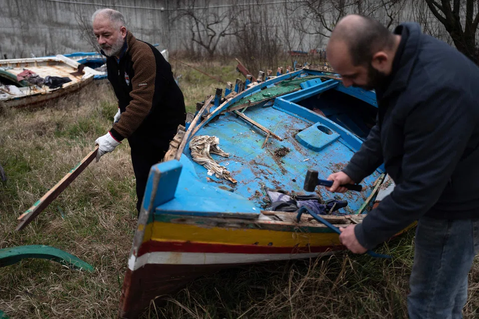 Inmates collect wood from a migrant boat to make music instruments as part of the "violins of the sea" project at the Opera near the Italian city of Milan.