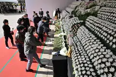 Mourners pay tribute in front of a joint memorial altar for victims of the deadly Halloween crowd surge in Seoul on October 31, 2022. 