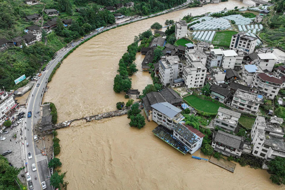 A damaged bridge and submerged buildings at a flood-affected village in Kaili, China, June 28, 2025. 