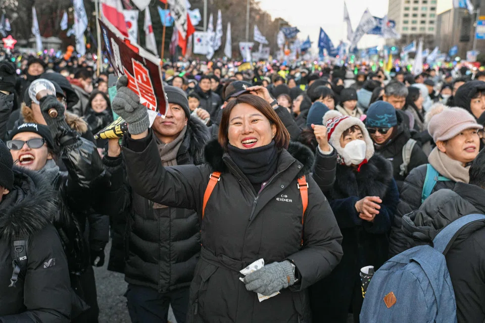 Protesters in Seoul celebrate after the result of the second martial law impeachment vote was announced on Saturday. Lawmakers successfully voted to remove Yoon from office for his failed attempt to impose martial law. 