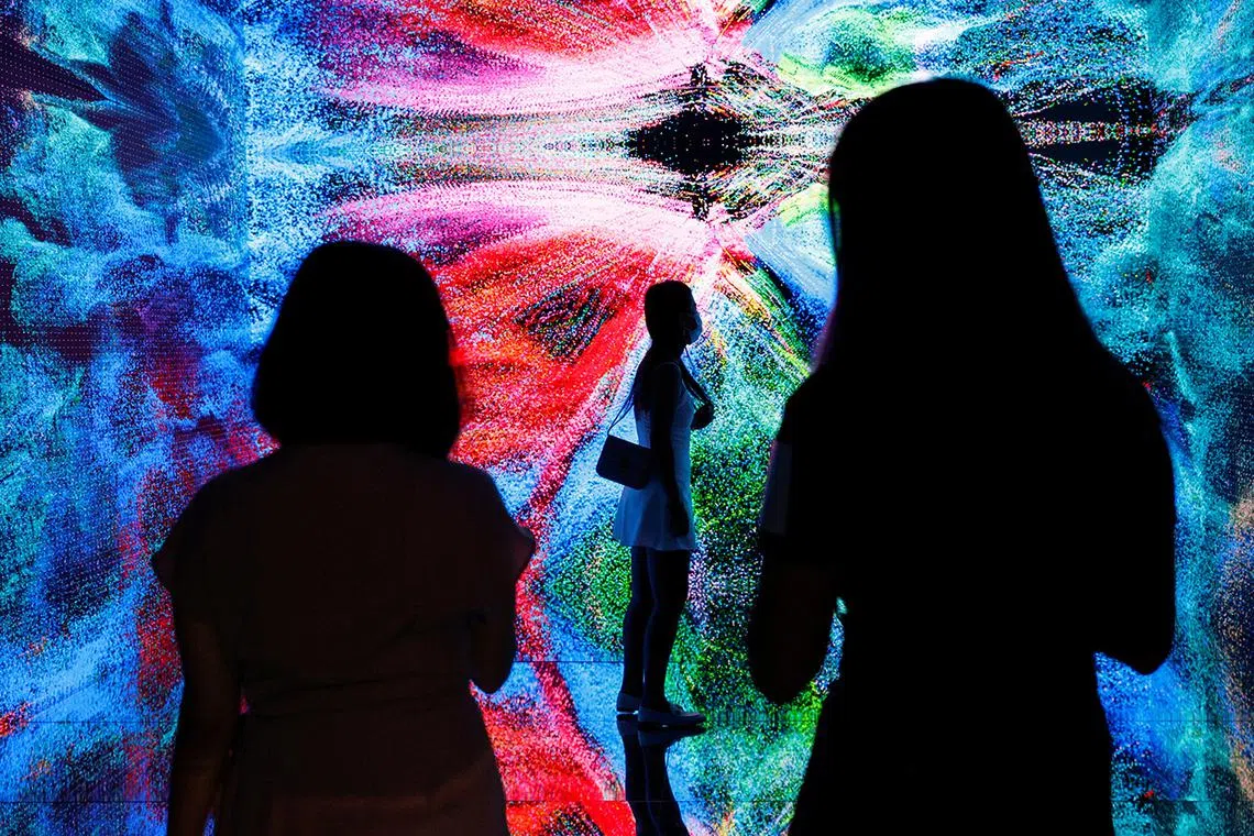 Visitors are pictured in front of an immersive art installation titled "Machine Hallucinations - Space: Metaverse" by media artist Refik Anadol, which will be converted into NFT and auctioned online at Sotheby's, at the Digital Art Fair, in Hong Kong, China September 30, 2021. REUTERS/Tyrone Siu     TPX IMAGES OF THE DAY##########pic##########