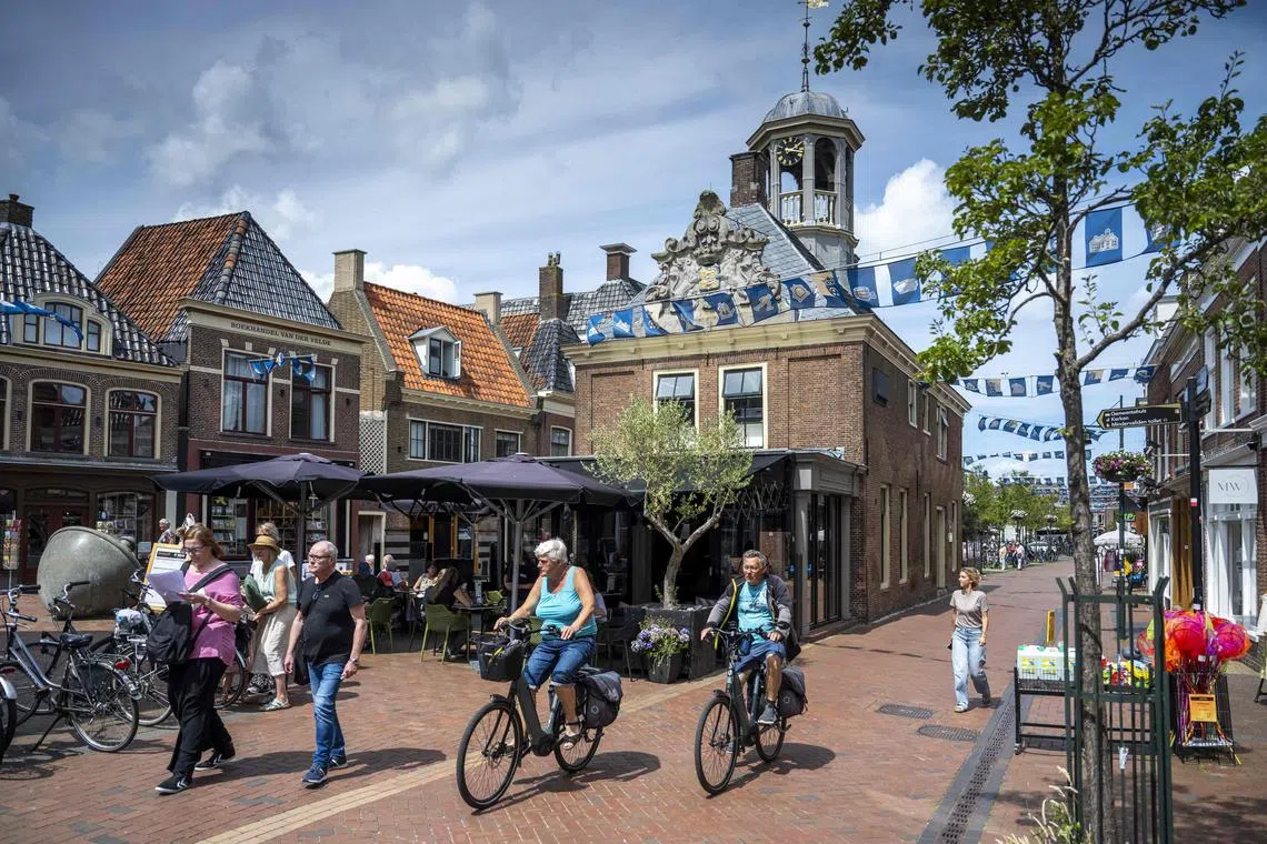 People ride their bikes down the street in Dokkum, the Netherlands. It has become increasingly common for full-time workers in the country to compress their hours into four days rather than spread them over five.