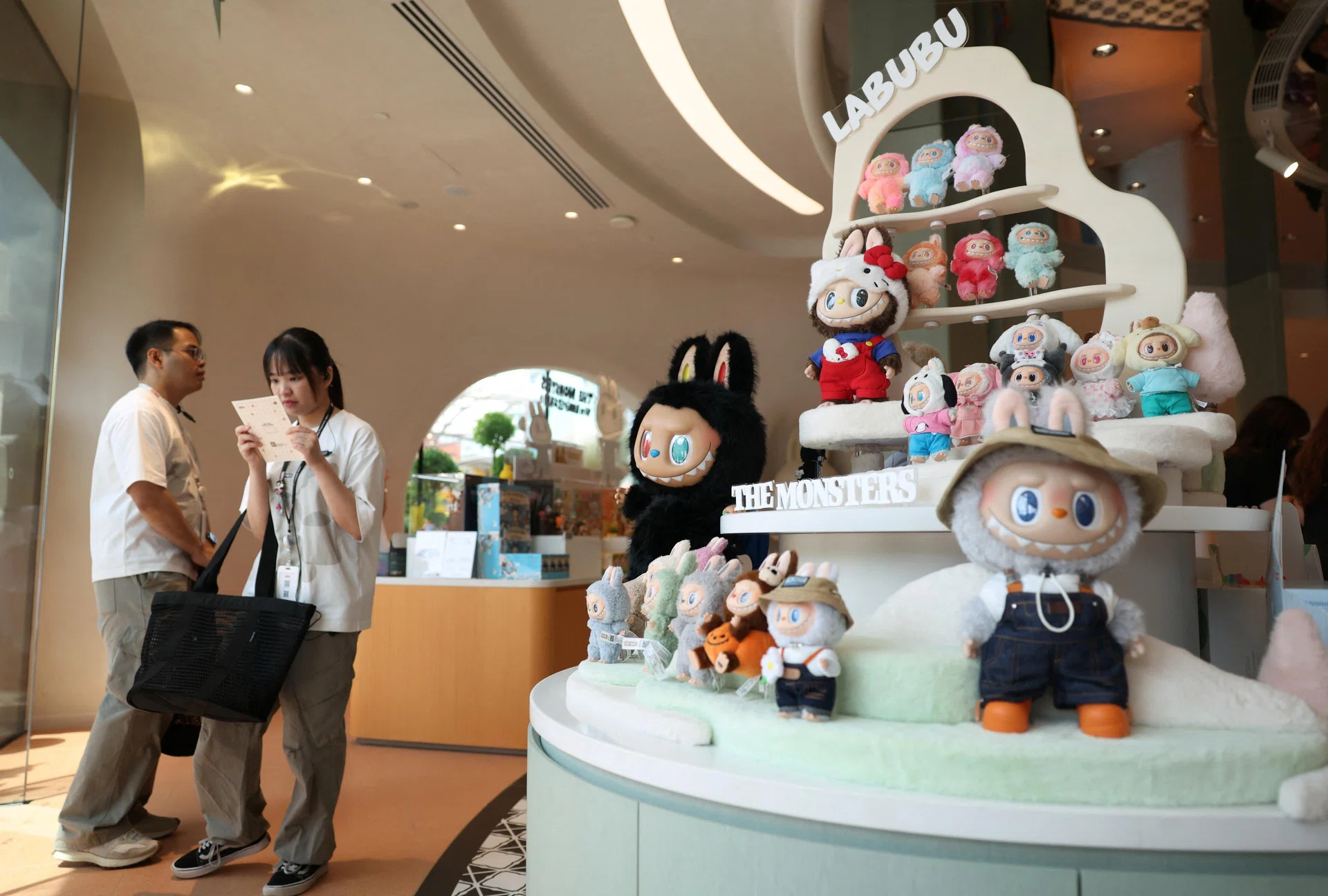 Guests waiting next to a shelf of Labubu toys at Pop Mart's first international bakery at Resorts World Sentosa in Singapore