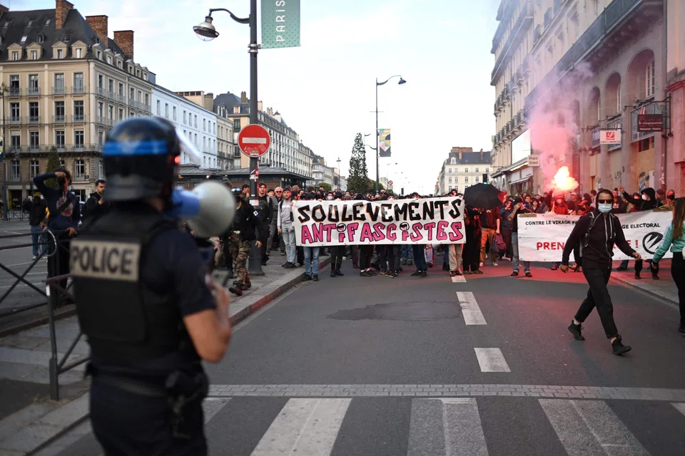 Supporters of the left wing coalition Nouveau Front Populaire (NFP) hold a banner reading "Anti-facist uprising" after the first results of the second round of France's legislative election emerged, Rennes, France, July 7, 2024. 