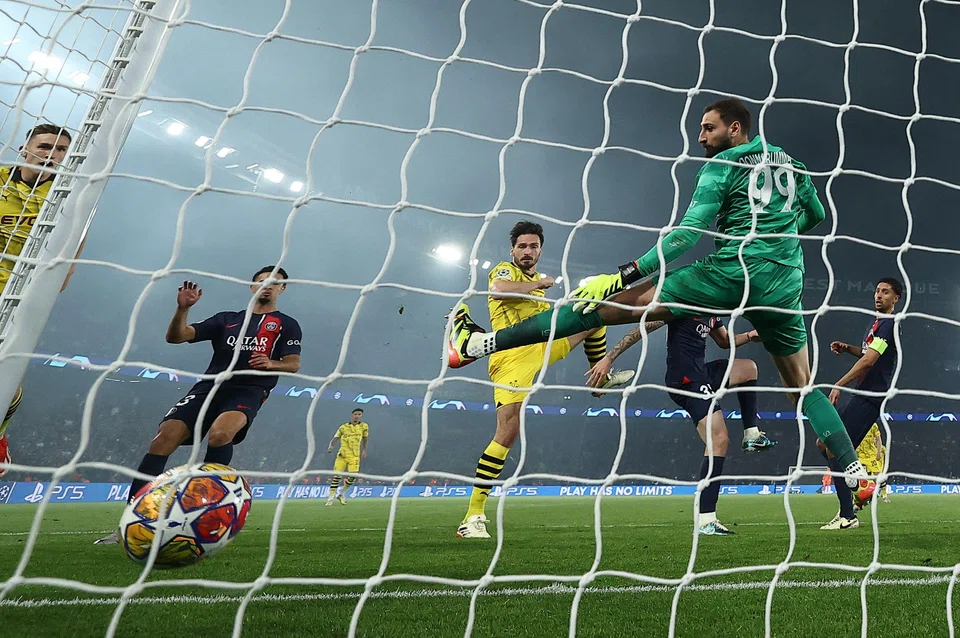 Dortmund's German defender Mats Hummels (centre) heads the ball past Paris Saint-Germain's Italian goalkeeper #99 Gianluigi Donnarumma (right) to score his team's first goal during the Uefa Champions League semi-final second leg football match between PSG and Borussia Dortmund at the Parc des Princes stadium in Paris, France, May 7, 2024. 