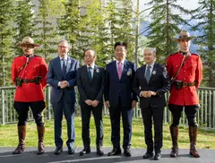 (Second from left) Bank of Canada Governor Tiff Macklem, Bank of Japan Governor Kazuo Ueda, Japanese Minister of Finance Katsunobu Kato and Canadian Finance Minister Francois-Philippe Champagne with Royal Canadian Mounted Police officers during the G7 finance ministers and central bank governors meeting in Banff, Canada, May 21, 2025.  