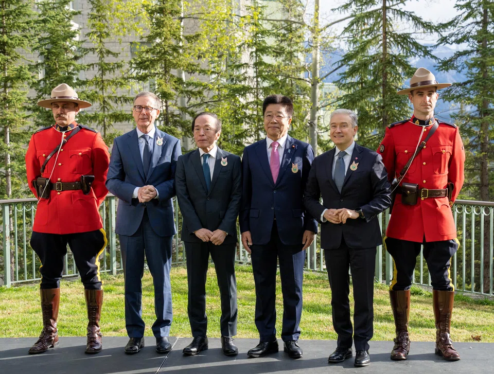(Second from left) Bank of Canada Governor Tiff Macklem, Bank of Japan Governor Kazuo Ueda, Japanese Minister of Finance Katsunobu Kato and Canadian Finance Minister Francois-Philippe Champagne with Royal Canadian Mounted Police officers during the G7 finance ministers and central bank governors meeting in Banff, Canada, May 21, 2025.  