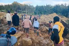 People gather at the site of a landslide in Maip Mulitaka in Papua New Guinea's Enga Province. The Australian Broadcasting Corp and other local media reported that more than 100 people had been killed. 