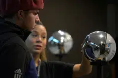 A man having his iris scanned with an orb, a biometric data scanning device, in exchange for the Worldcoin cryptocurrency.