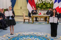 Imelda Tanoto, managing director at RGE (foreground, right) and Helle Kristoffersen (foreground, left), president Asia and member of the executive committee at TotalEnergies, announced a co-investment agreement between RGE and TotalEnergies in the presence of Indonesian President Prabowo Subianto (background, right) and French President Emmanuel Macron.