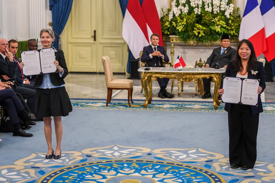 Imelda Tanoto, managing director at RGE (foreground, right) and Helle Kristoffersen (foreground, left), president Asia and member of the executive committee at TotalEnergies, announced a co-investment agreement between RGE and TotalEnergies in the presence of Indonesian President Prabowo Subianto (background, right) and French President Emmanuel Macron.