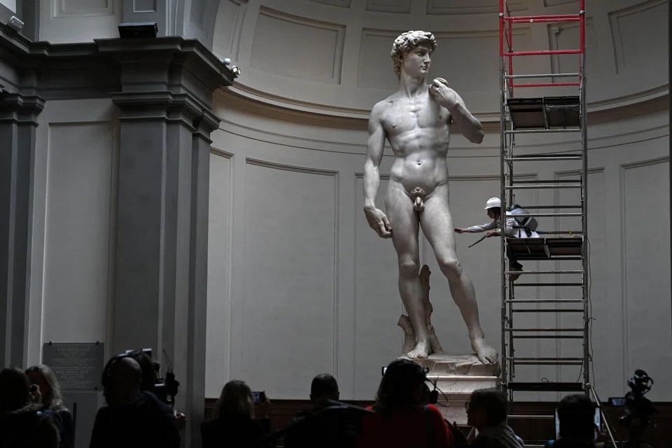 An Italian restorer cleans Michelangelo's statue of David using a portable vacuum and synthetic fibre brush at Florence’s Accademia Gallery.