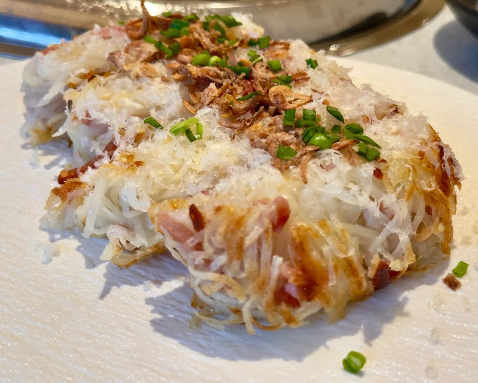 Pan-fried shredded potato pancake with bacon and cheese.