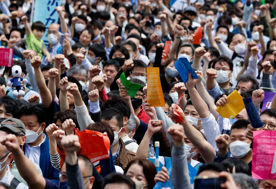 Members of the Japanese Trade Union Confederation, commonly known as Rengo, raise their fists as they shout Gambaro and cheer during their annual May Day rally to demand higher pay and better working conditions, in Tokyo on Apr 29, 2023. 