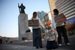 Kpop4planet activists Park Jin-hui, Kim Na-yeon, and Roza de Jong work on a short-form video, in central Seoul.