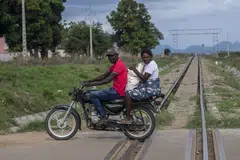 People crossing railway tracks in Cubal, Angola. The railway is part of the Lobito Corridor that connects the country with Zambia and the Democratic Republic of Congo. 