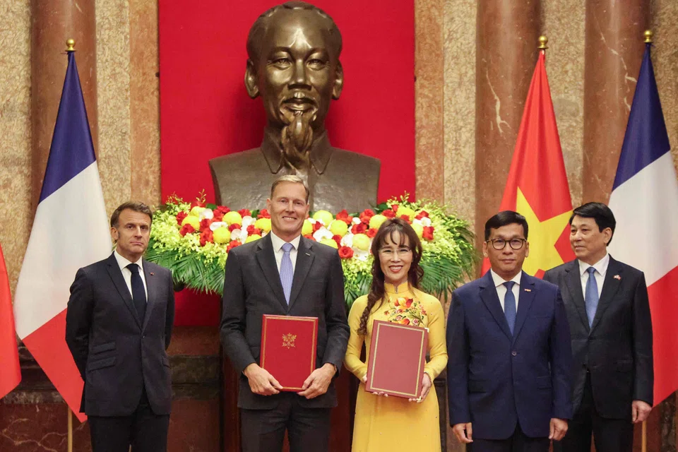 From left: France's President Emmanuel Macron, Airbus executive vice-president Wouter van Wersch, Vietjet's chairwoman Nguyen Thi Phuong Thao, Vietjet's CEO Dinh Viet Phuong and Vietnam's President Luong Cuong pose after signing a trade agreement at the Presidential Palace in Hanoi on May 26. 