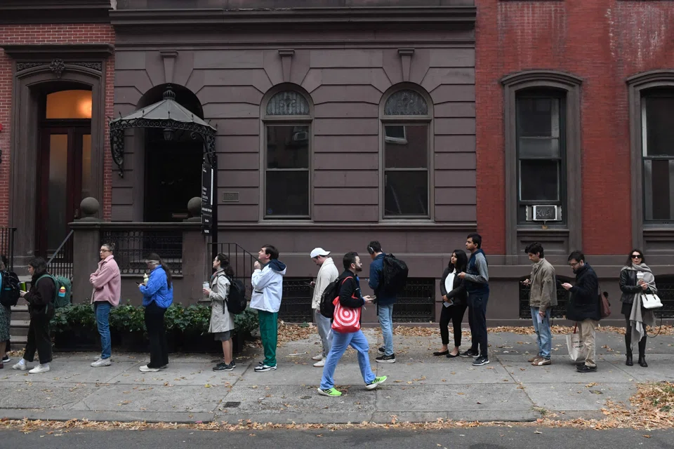 People line up to vote outside a polling station in Philadelphia, Pennsylvania on Election Day. Overnight, six registered voters in the tiny hamlet of Dixville Notch, New Hampshire, split their votes between Harris and Trump in voting just past midnight.