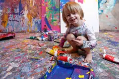 Laurent Schwarz, three years old, smiles as he creates an artwork in his studio in his parents' house in Neubeuern near Rosenheim, southern Germany.