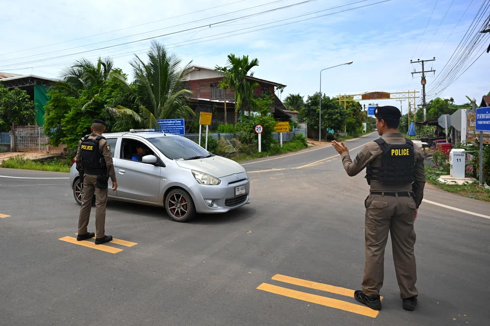 Thai police direct traffic during the villagers' evacuation, amidst clashes between Thai and Cambodian soldiers near the Thai-Cambodian border, in Ban Ta Miang, Surin province, Thailand on Jul 24.