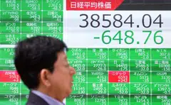 A man walks past an electronic board showing the Nikkei index of the Tokyo Stock Exchange in Tokyo, Japan, April 16, 2024. Tokyo, Hong Kong, Shanghai, Seoul, Singapore, Taipei, Wellington, Manila and Jakarta stocks were all sharply down on Tuesday.