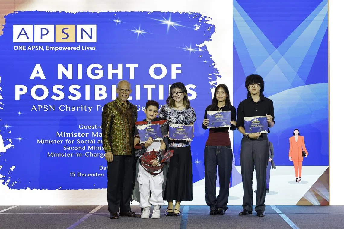 Minister for Social and Family Development,Masagos Zulkifli hands out certificates to the participating designers and models.