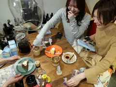 Momoka Matsui and her co-worker Saki Matsumoto prepare to take photos of acrylic stand figure models of their favourite idols with cakes and teas, which they ordered at After All Coffee, where Matsui’s favourite boy band stopped by, Tokyo, Japan, March 23, 2025.
