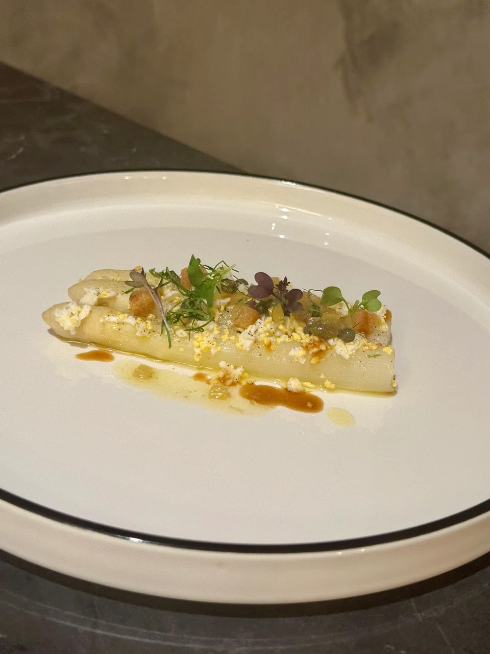 Slim white asparagus topped with crumbled egg and croutons.