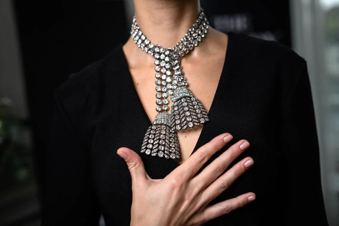 A woman wearing an 18th century diamond jewel necklace composed of three rows of diamonds finished with a diamond tassel at each, weighing approximately 300 carats, at a press preview at Sotheby's in Geneva, Switzerland, Nov 7, 2024. 