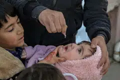 A child receives an anti-polio vaccine during a door-to-door vaccination campaign in Kabul, Afghanistan.