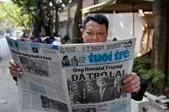 A man reading a Vietnamese newspaper with a front page story on the inauguration of US President Donald Trump; while Trump's earlier threats of tariffs are not off the negotiating table yet, pundits say Asean now has more leverage.