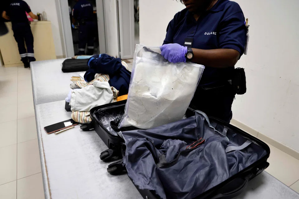 French customs officers discover cocaine hidden in a suitcase as they inspect the bags of a passenger flying to Paris from Cayenne at the international airport in Cayenne, French Guiana, March 24, 2024. 