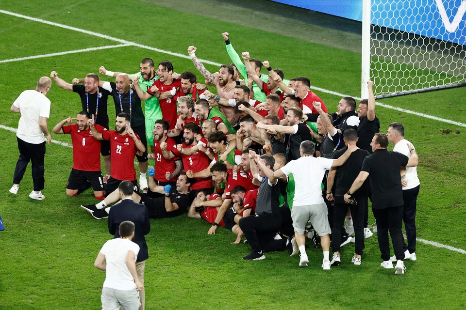Georgian players celebrate after winning their match against Portugal in Gelsenkirchen, Germany, June 26, 2024. 