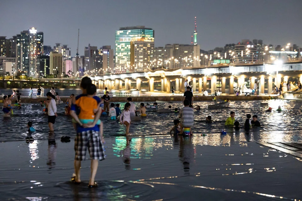 People visit at Yeouido Hangang Park at night in Seoul, South Korea, Aug 3, 2024. The Korea Meteorological Administration has issued a heat wave warning across the country on Aug 6. High nighttime temperatures can become dangerous if they prevent the human body from cooling off and recovering from daytime heat, said WHO. 
