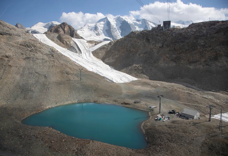 Snow from the last winter season is covered with blankets on a slope beside the top station of a cablecar at Diavolezza ski area near the Alpine resort of Pontresina, Switzerland Jul 21, 2022.  
