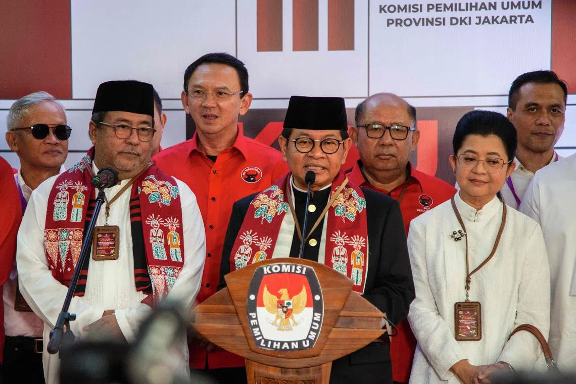 Pramono Anung (centre) and his running mate Rano Karno (left) attend a press conference after registering as candidates for Jakarta governor and deputy governor.