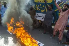 Demonstrators burn India's national flag and photos of Narendra Modi, India's prime minister during a protest in response to India's military strikes against Pakistan.