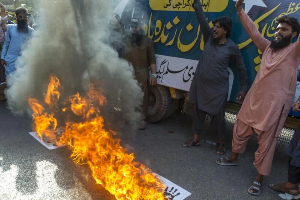 Demonstrators burn India's national flag and photos of Narendra Modi, India's prime minister during a protest in response to India's military strikes against Pakistan.
