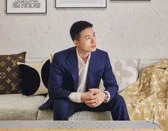 Soh Jun Wei wears a Louis Vuitton cream white shirt, navy blue suit, ring and Escale rose gold in blue dial watch.