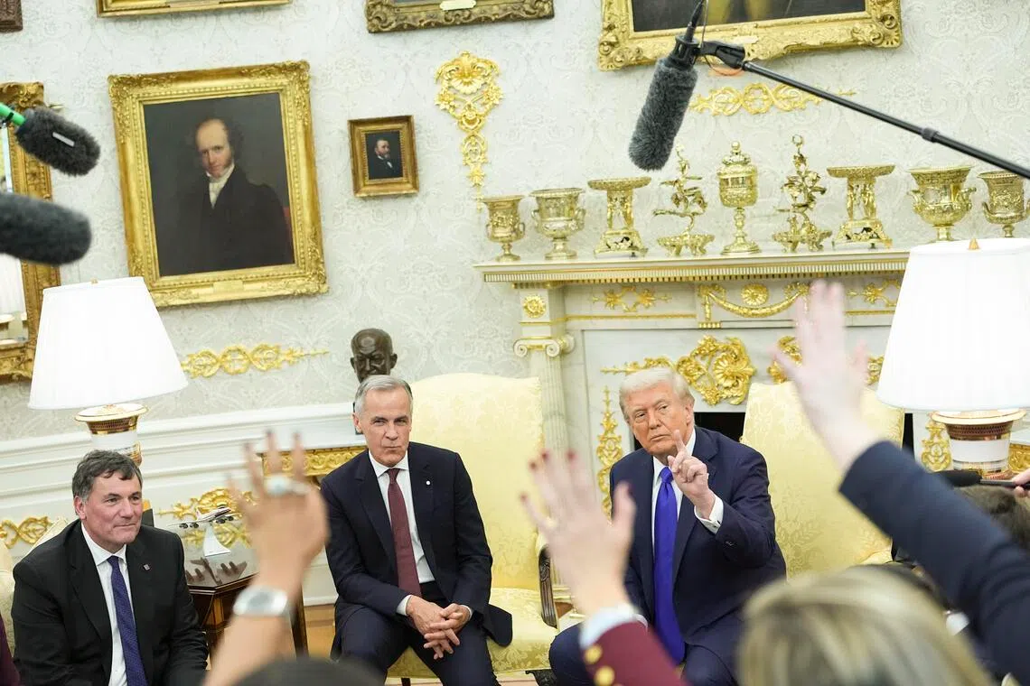 Canadian Prime Minister Mark Carney (centre) with US President Donald Trump (right) in the White House on Oct 7. The new tariff would greatly increase US duties on its northern neighbour, adding pressure to Canadian industrial sectors such as metal manufacturing, cars and machinery.