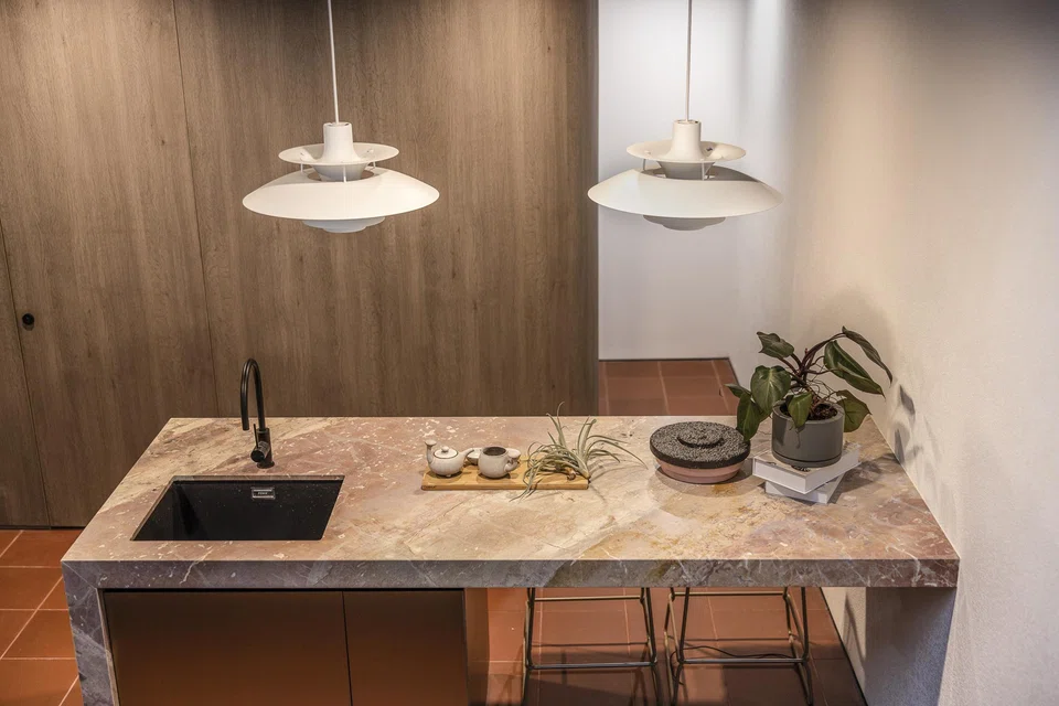 The dry kitchen with terracotta-coloured tiles and salmon-coloured stone table top.