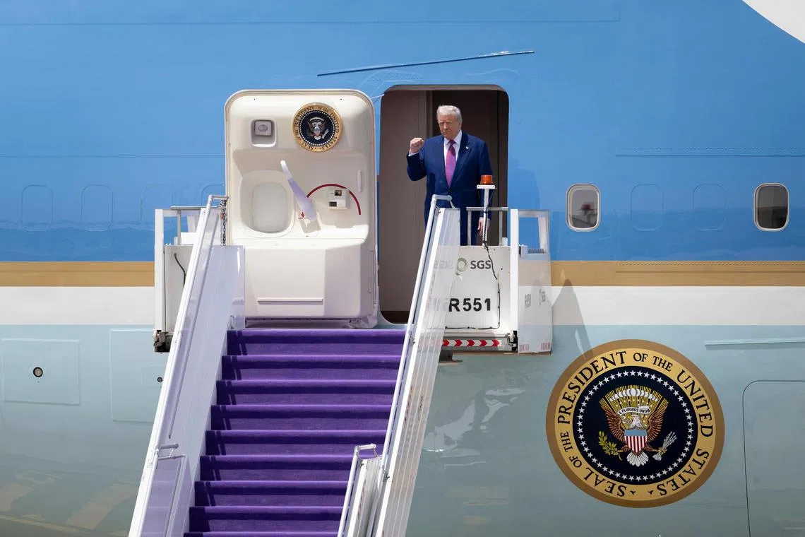 US President Donald Trump gestures as he exits his plane upon arriving at the airport in Riyadh, Saudi Arabia, May 13, 2025. Trump's decision to accept a luxury jet from Qatar is the latest in a barrage of ethical conflicts that opponents say have blurred the line between his public role and private business interests.