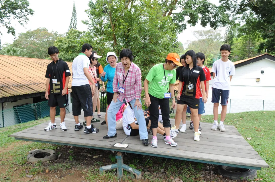 Seniors and young people participating in a balancing game at an intergenerational camp organised by the South East Community Development Council, December 2010. 
