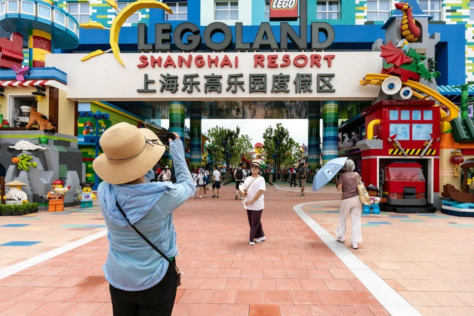 Visitors pose for photographs at the entrance to Legoland Shanghai Resort during a media preview in Shanghai, China, June 20, 2025.